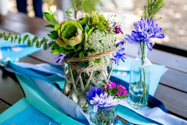 Dışarıdaki masada, basit çiçek merkezi parçaları.