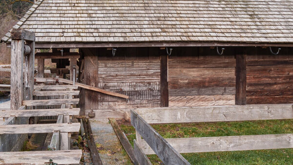 Водяная мельница с деревянной крышей и деревянным забором