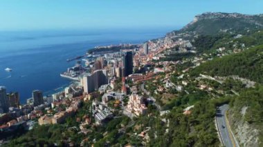 Montecarlo 'nun zengin şehri, yüksek binalar, Formula 1 yarışı ile ünlü dar sokaklar. Dağ, deniz ve güzel şehir güneşli bir günde ve zengin şehirde yatları ve lüks arabaları olan turizm