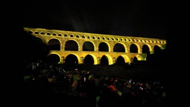 Fransa 'nın güneyinde yer alan Pont du Gard' ın gece fotoğrafı. Antik Roma su kemeri. Dünyanın her yerinden turistleri çeken görkemli ünlü bir köprü. Işıklarla aydınlatılan mimari işler.