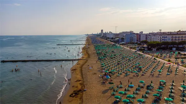 stock image Aerial view of Jesolo beach, near Venice in Italy, coast with sunset. Adriatic Sea in the Mediterranean with beaches full of tourists on holiday and traveling in summer. Top view of the beach, umbrellas, hotels, resorts and sea waves