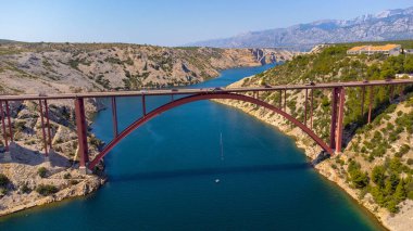 Denizin üzerindeki bir köprüden bungee jumping aktivitesi. Köprüdeki bir ipe bağlı havadan gören biri. Maslenica köprüsü, Hırvatistan, seyahat merkezleri.