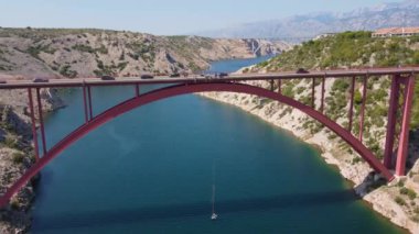 Hava manzaralı Maslenica köprüsü, Hırvatistan. Denizin üzerindeki kırmızı kemer köprüsü. Hırvatistan 'ın peyzaj ve harikalarını ziyaret etmek üzere yola çıktı.