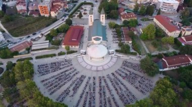 Bosna-Hersek 'in Medjugorje kentinde dini kutlamalara katılan insanlardan oluşan hava manzaralı bir kalabalık. Yarı daire içinde konumlanmış bir grup insan.