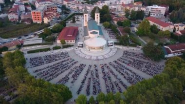Medjugorje 'nin turist kasabasında gün batımı. Kilisenin havadan görünüşü ve insanların dini bir kutlamaya katılması..