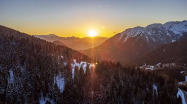 Kar kaplı dağlarla kış günbatımı manzarası. Hava manzarası, merkezli güneş, Brocon Geçidi, Lagorai.