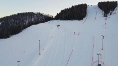 İki kar aracı kayak pisti hazırlıyor. Kışın dağlarda ağaçlar arasındaki iki aracın hava görüntüsü