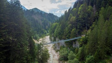 Doğanın ortasındaki bir kanyonda Tibet köprüsü. Trentino 'daki Noana Vadisi' nde asılı halat köprüsünün hava görüntüsü.