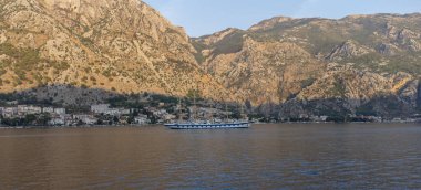 Akdeniz 'de, arka planda dağlarla birlikte Kotor Körfezi' ndeki görkemli yelkenli gemisinin sularının alçak açılı görüntüsü.