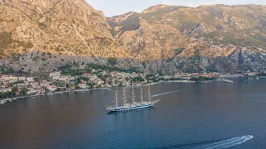 Royal Clipper yelkenli gemisinin gün batımı manzarası Kotor Körfezi 'nde, dağların arasında. Kullanılmış seyahat ve tatiller