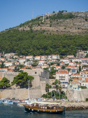 Dubrovnik 'in tarihi limanında dağ arkaplanlı bir tekne manzarası. Adriyatik Denizi 'nin turistik kentinde liman