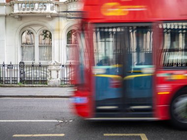 Londra kırmızı otobüsü Londra 'da şehir ve Birleşik Krallık' ın sembolü olan bir cadde boyunca hareket halinde. Deneğin hızlı hareket etmesinin bulanık etkisi