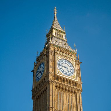 Aşağıdan Big Ben kulesinin temiz mavi arkaplanlı görüntüsü. Tarihi yapı, İngiltere 'nin ünlü İngiliz şehri Londra' nın turistik merkezi.