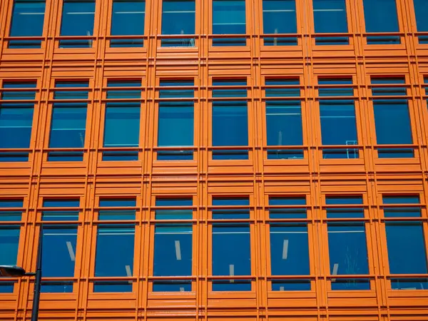 Pencereli turuncu bina cephesinin soyut şehir görüntüsü. Londra sokaklarında Saint Giles binalarının dış binaları inşa ediliyor.