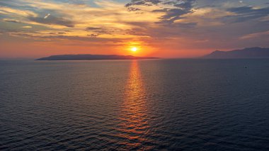 Hırvatistan kıyılarından deniz üzerindeki günbatımının muhteşem, rahatlatıcı manzarası. Batan güneşin ve uçsuz bucaksız Adriyatik Denizi 'nin havadan görünüşü