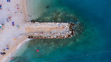 Makarska kentindeki Hırvat plajındaki dalgakıranın en aşağı manzarası. Kıyı ve mavi Adriyatik Denizi 'nin havadan görünüşü