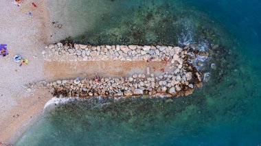 Makarska kentindeki Hırvat plajındaki dalgakıranın en aşağı manzarası. Kıyı ve mavi Adriyatik Denizi 'nin havadan görünüşü