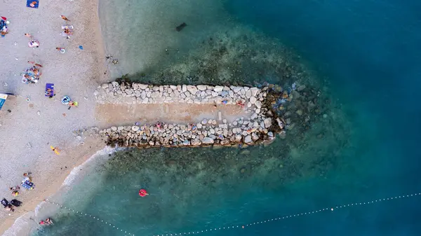 Makarska kentindeki Hırvat plajındaki dalgakıranın en aşağı manzarası. Kıyı ve mavi Adriyatik Denizi 'nin havadan görünüşü