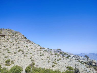 Açık mavi gökyüzüne karşı açık hava aktiviteleri sırasında dağların manzarası