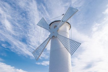 Swinoujscie 'deki eski deniz feneri, Polonya' da Baltık Denizi kıyısında bir liman. Deniz feneri geleneksel bir yel değirmeni olarak tasarlandı..