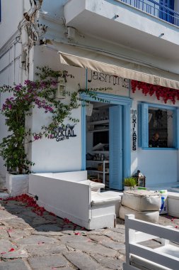Skiathos Yunanistan 06-26-23. Skiathos Adası 'ndaki Picturesque Cafe Bar' da. Koltuklar, masalar ve sandalyeler. Mavi deniz ve gökyüzü Ege manzarası, tipik bir turizm mekanı.