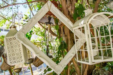 Dekoratif restoran girişi, tepe örtüsünde soyut nesnelerin asılı olduğu beyaz bohem titreşimler..     