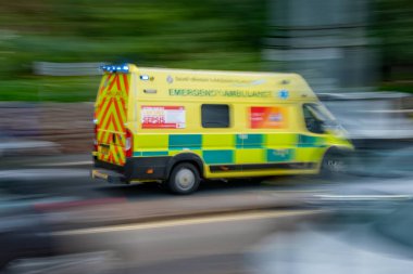 Torquay, Devon, uk. 09-18-23. Kan zehirlenmesi. Hareket halindeki bir acil ambulans bulanık ama yanında sepsis bilgisi işareti var. Mavi ışıklar yanıp sönüyor. Sağlık görevlileri acil bir durumla ilgileniyorlar.. 