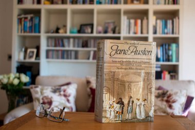 Ideford, Devon, İngiltere. 15 Nisan 2023. Jane Austen 'ın eserleri. Resim, yumuşak odaklı bir kitaplık arka planına göre ayarlanmış. Ön kapağa seçici odaklanma.