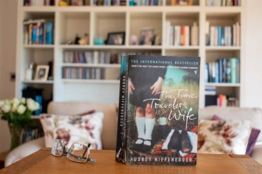 Audrey Niffenegger 'ın zaman yolcusu karısı. Resim, yumuşak odaklı bir kitaplık arka planına göre ayarlanmış. Ön kapağa seçici odaklanma.