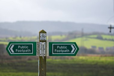 Exeter, Devon uk. 17 Mart 2023. Bir İngiliz kır yürüyüşünde halk yolu işaretleri. Tahta bir direk, Halk Yolunu gösteren yeşil ve beyaz bir tabelayı destekler. İşarete odaklan.