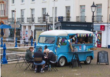 Torquay, Devon, uk. 17 Şubat 2023. Yanında insanlar oturan mavi renkli bir Citroen HY servis minibüsü. Kahve satışı için kullanılan klasik bir Fransız minibüsü. Uzayı kopyala Masadaki lokantalara odaklan..