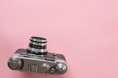 Diptford, Devon, İngiltere. 2 Şubat 2023. Üst perspektiften çekilmiş 35 mm 'lik eski bir kamera. Rus Fed 4 model eski kamera. Pembe arka planda. Retro kamera. Boşluğu kopyala.