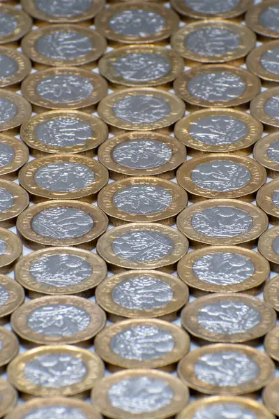 Pound coins laying flat with a shallow depth of field. Selective focus on the centre coins. Ideal financial background image of British pound coins.Editorial.