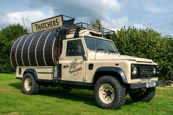 Banwell, Kuzey Somerset, İngiltere. 22 Eylül 2022. Thatchers elma şarabı koruyucusu. Arkasında Thatchers Elma Şarabı tahta fıçısı olan 4X4 off-road aracı. Dört çeker sağlam araba. Alkol..