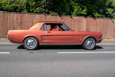 Powderham, Devon, İngiltere. 9 Temmuz 2022. 9. 2022. 1960 'ların Ford Mustang kaslı arabası Emberglo Metalik renginde. Nadir bulunan tarihi V8 Amerikan arabası. Şık, seksi, hızlı ve çekici.. 