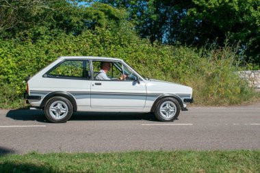 Powderham, Devon, İngiltere. 9 Temmuz 2022. Ford Fiesta XR2 klasik beyazlı araba köy yolunda gidiyor. Alaşımlı tekerlekleri olan hızlı bir Ford, kollektif ve arzu edilen tarihi araç.