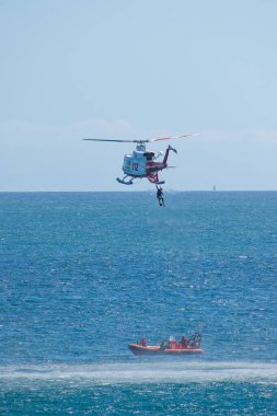 Santander, İspanya. 28 Haziran 2022. Helikopter kurtarma. Bir İspanyol hava kurtarma helikopteri denizden bir dalgıç getirdi. Motorun ısı sisi kurtarılan dalgıç ve yüzücünün üzerine çarpıcı bir parıltı ekliyor..