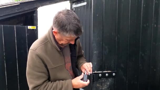 농부는 손상을 검사합니다 손상된 자물쇠를 수갑이 파괴된 검은색 자물쇠 기계의 — 비디오