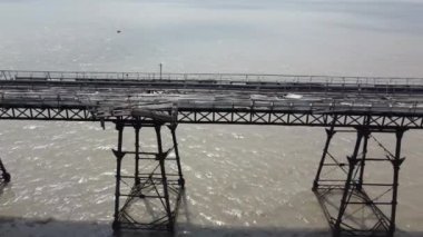 Birnbeck, Birleşik Krallık. 12-02-22. Çökmek üzere olan harap olmuş bir iskelenin insansız hava aracı görüntüsü. Çürümüş ahşap ve çökmüş yapı İHA deniz kıyısı iskelesi boyunca hareket ederken. 