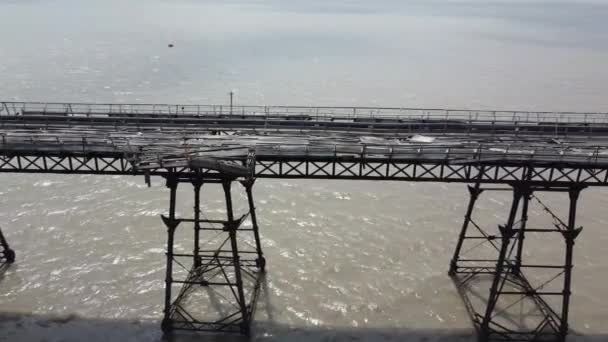 バーンベック イギリス 22について 崩壊に近い枯渇した桟橋のドローンビュー 海辺の桟橋の長さに沿ったドローンパンとしての腐った木材と崩壊構造 — ストック動画