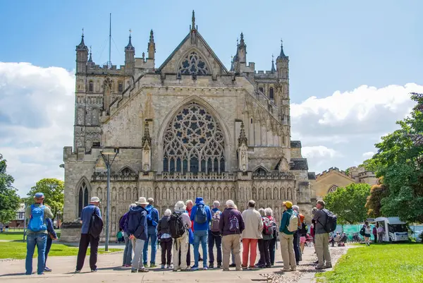 stock image Exeter, Devon, uk. 06-05-24. Exeter Cathedral with tourists on a guided tour gathered in front. A spectacular and popular city landmark. Landscape format image.