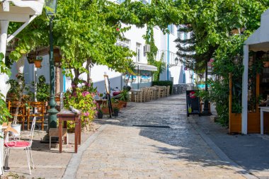 Skiathos greece. 06-23-24. Skiathos, Yunanistan. Kafeleri ve restoranları olan beyaz bir Skiathos sokağı. Sporades adalarında güzel bir tatil yeri.