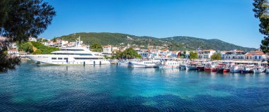 Skiathos, Yunanistan. 06-24-24. Skiathos limanı, teknelerin demirlediğini gösteriyor. Süper bir yat ve charter baots renkli sahneyi tamamlıyor. Sporades adaları. 