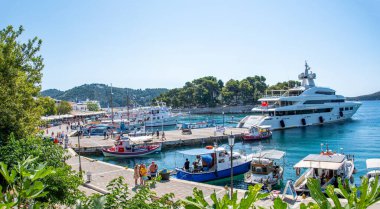 Skiathos, Yunanistan. 06-24-24. Skiathos limanı, teknelerin demirlediğini gösteriyor. Süper bir yat ve charter baots renkli sahneyi tamamlıyor. Sporades adaları. 