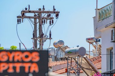 Skiathos, Yunanistan. 06-23-24. Mavi gökyüzüne karşı güneş suyu ısıtıcıları. Güneşin enerjisini kullanan sıcak su..