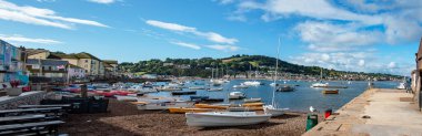 Teignmouth, Devon, İngiltere. 09-12-24. Teignmouth panoramik resmi arkadaki kumsalı ve Shaldon 'u gösteriyor. Tekneler ve mavi gökyüzü.