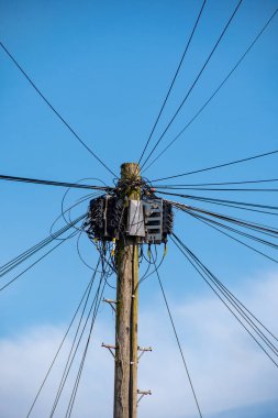 Telgraf direğindeki kablolar ve kablolar mavi gökyüzüne karşı. Telefon ve iletişim görüntüsü. Bilim ve teknoloji kavramı.