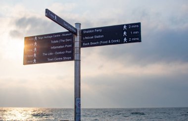 Teignmouth seafront signpost  with tourist information listing local attractions. Teignmouth lido, Teign heritage centre. Devon tourism. South Devon.  clipart