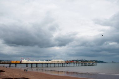 Paignton, Devon, İngiltere. 09-27-24. Paignton İskelesi sahilde el ele yürürken görülüyor. Torbay ve İngiliz Rivierası