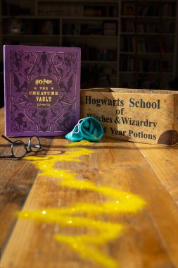 Torbryan, Devon, İngiltere. 10-26-24. Yaratık Kasa Kitabı. Harry Potter. Atmosferik resim, karanlık bir kitaplığın arka planında geçen büyülü altın çizgisi..